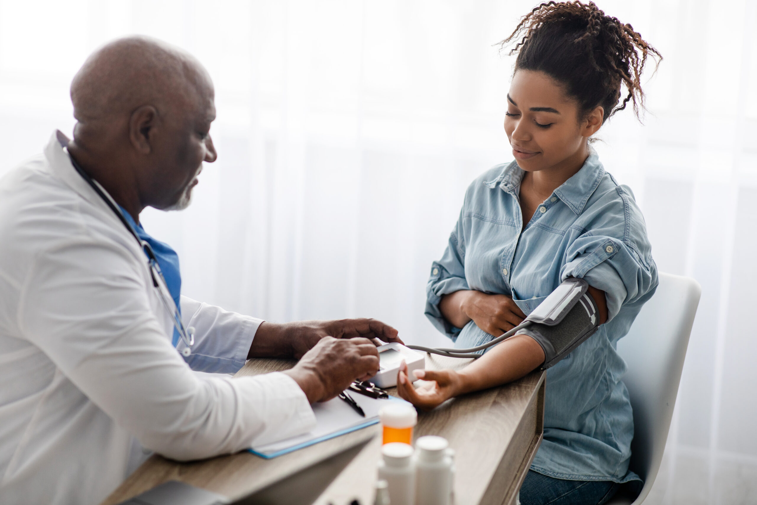 A woman is taking her blood pressure at the doctor 's office.